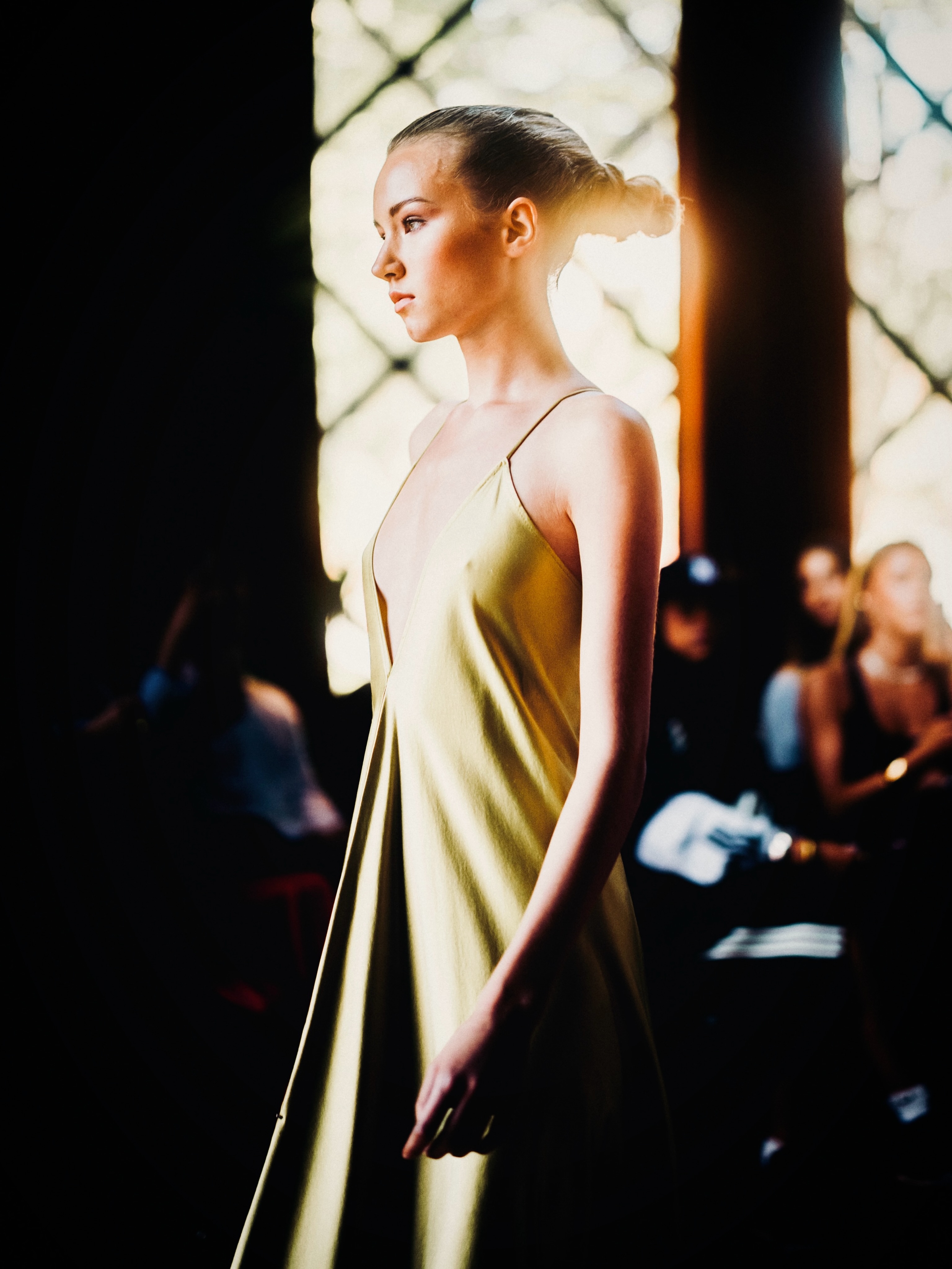 A model presents a gold look on the runway.