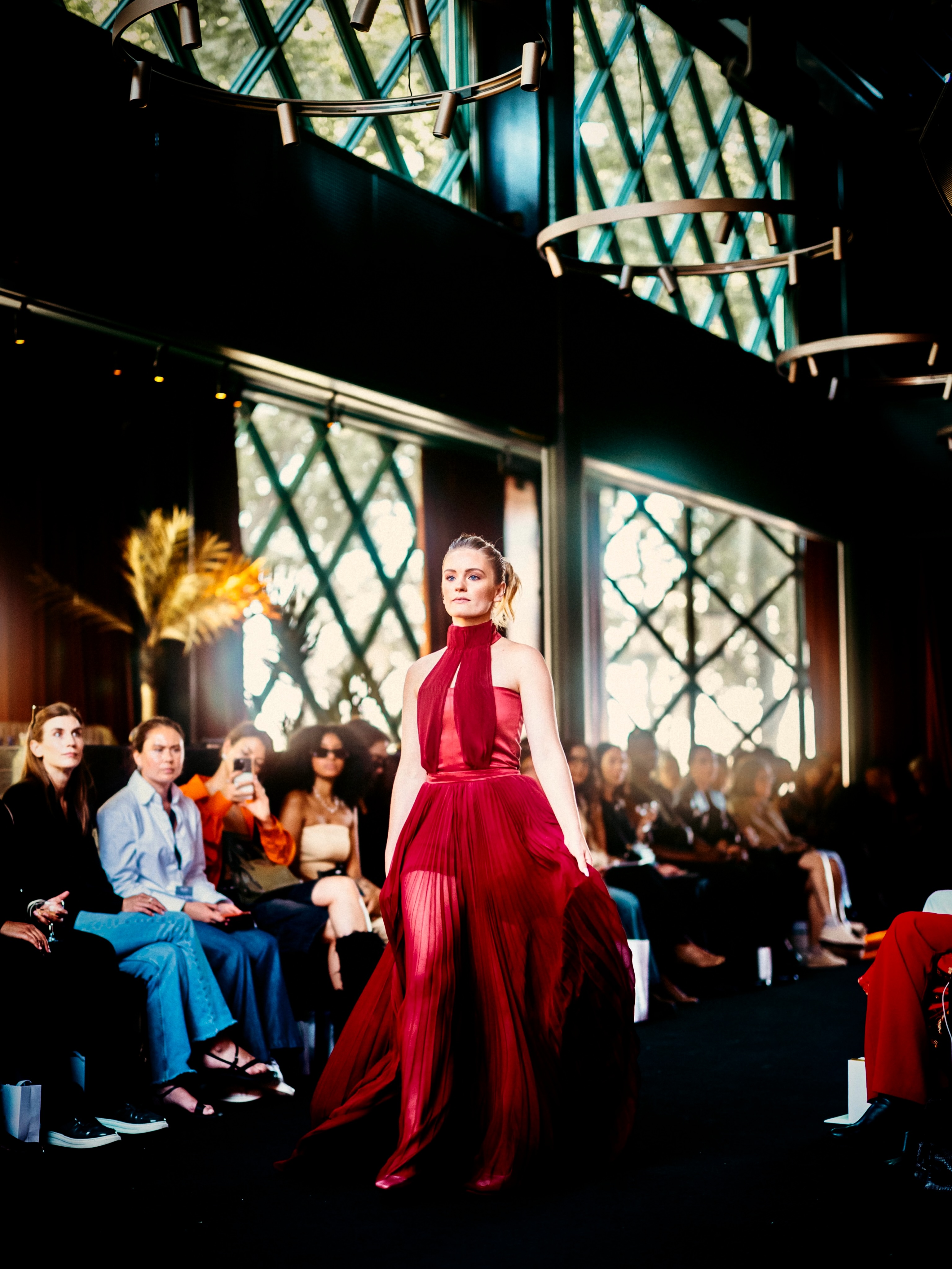A model presents a red look on the runway.