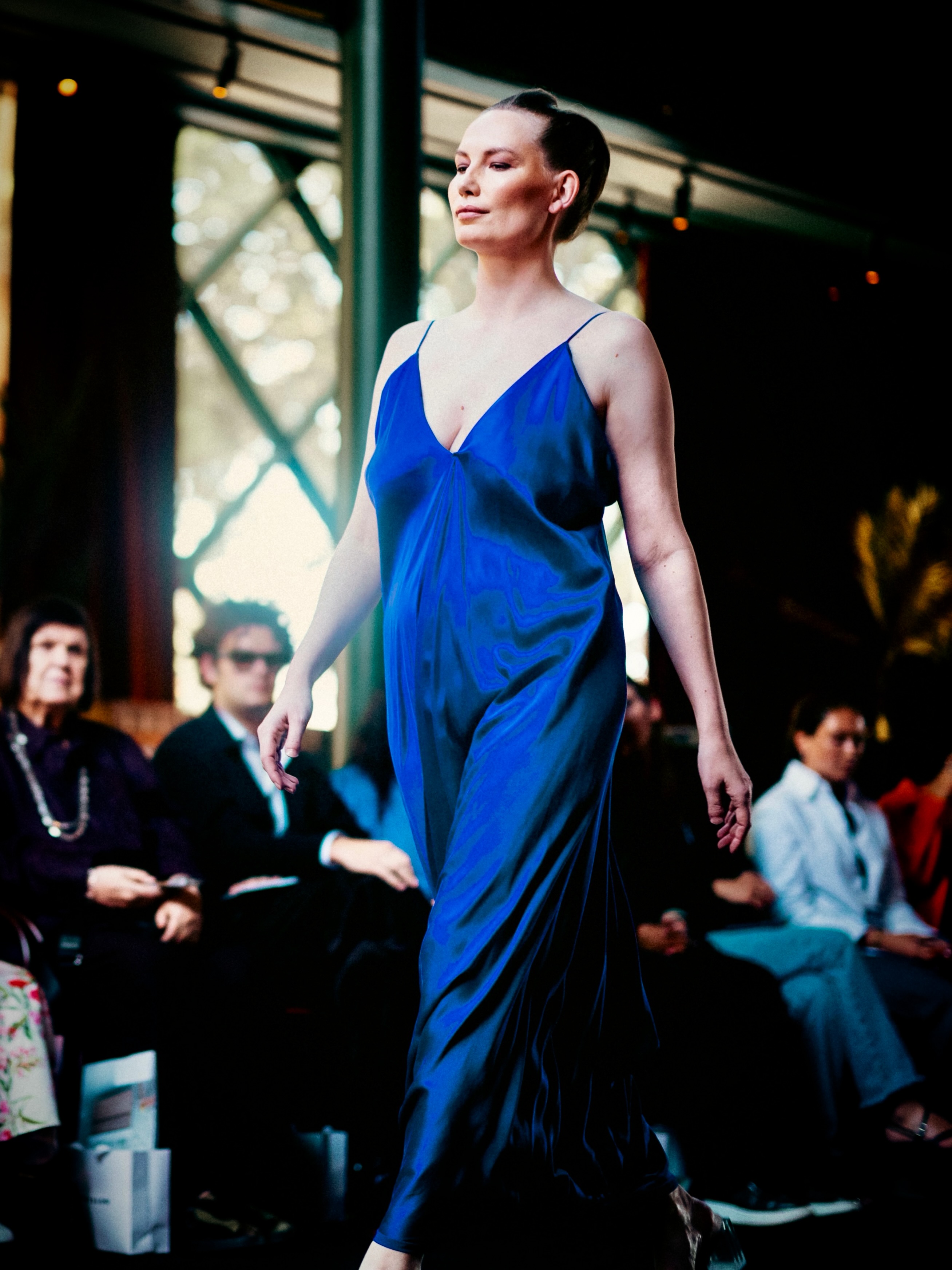 A model presents a blue look on the runway.