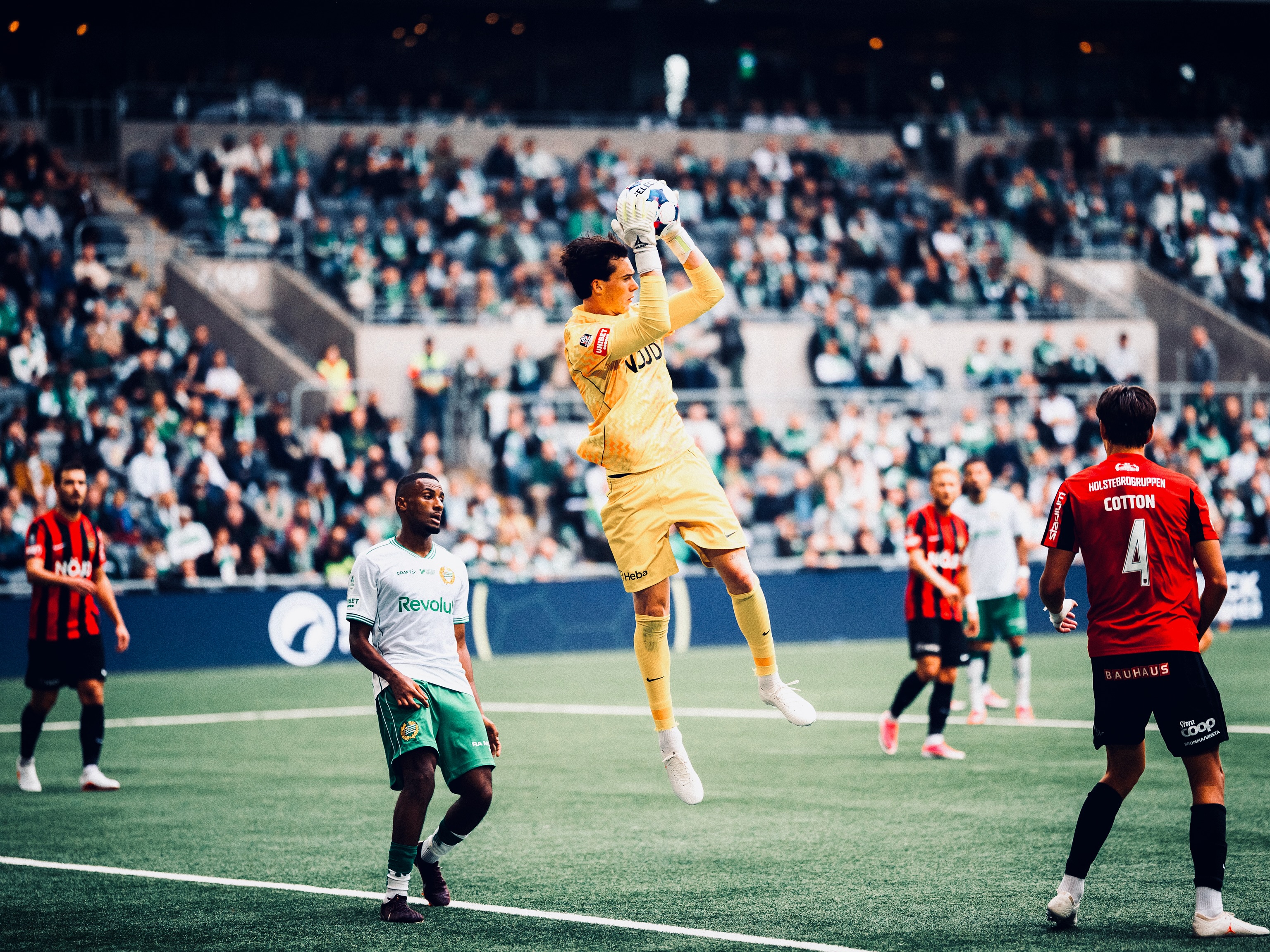 The goalkeeper reaches for the ball in the penalty area.