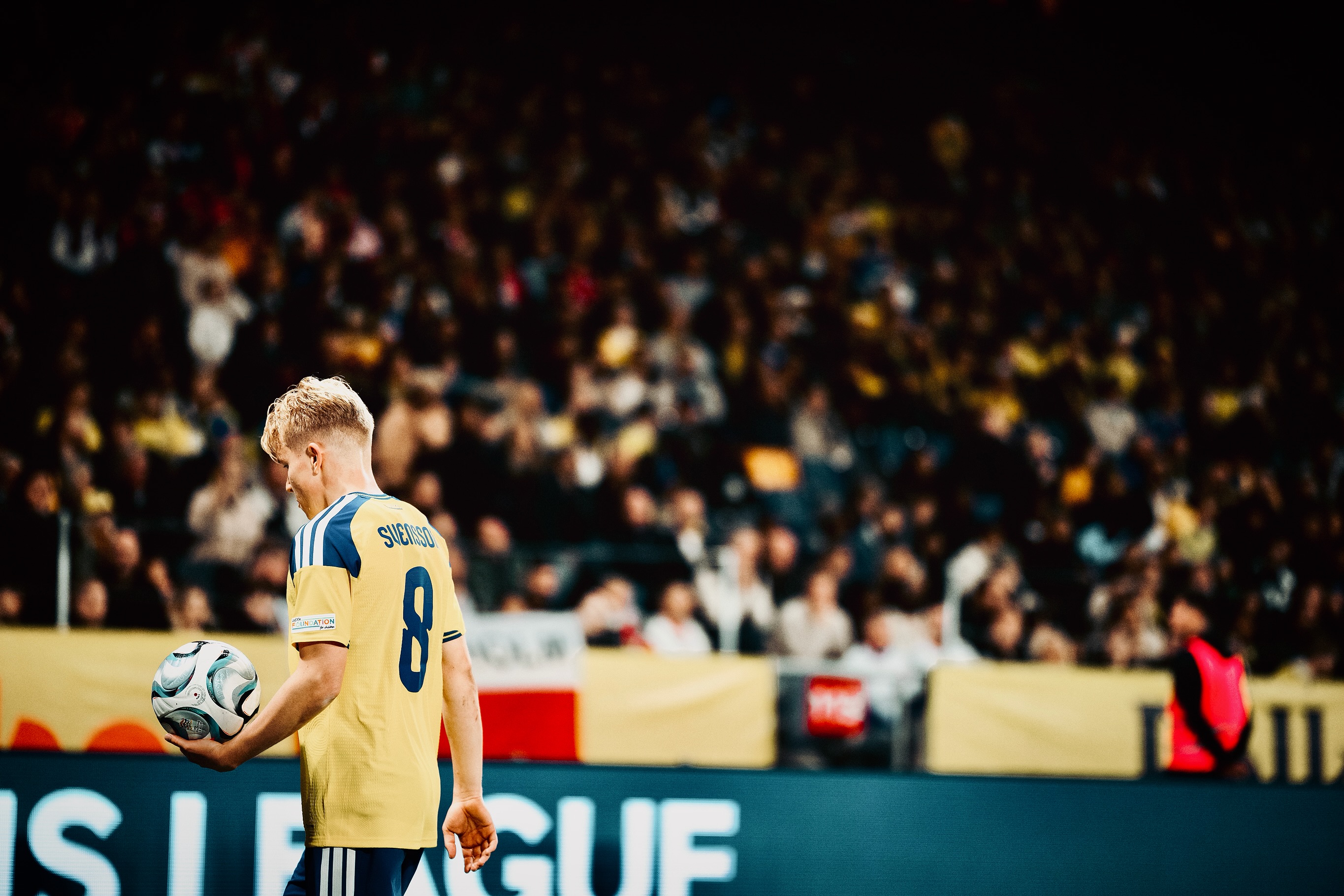 A Swedish player holds the ball.