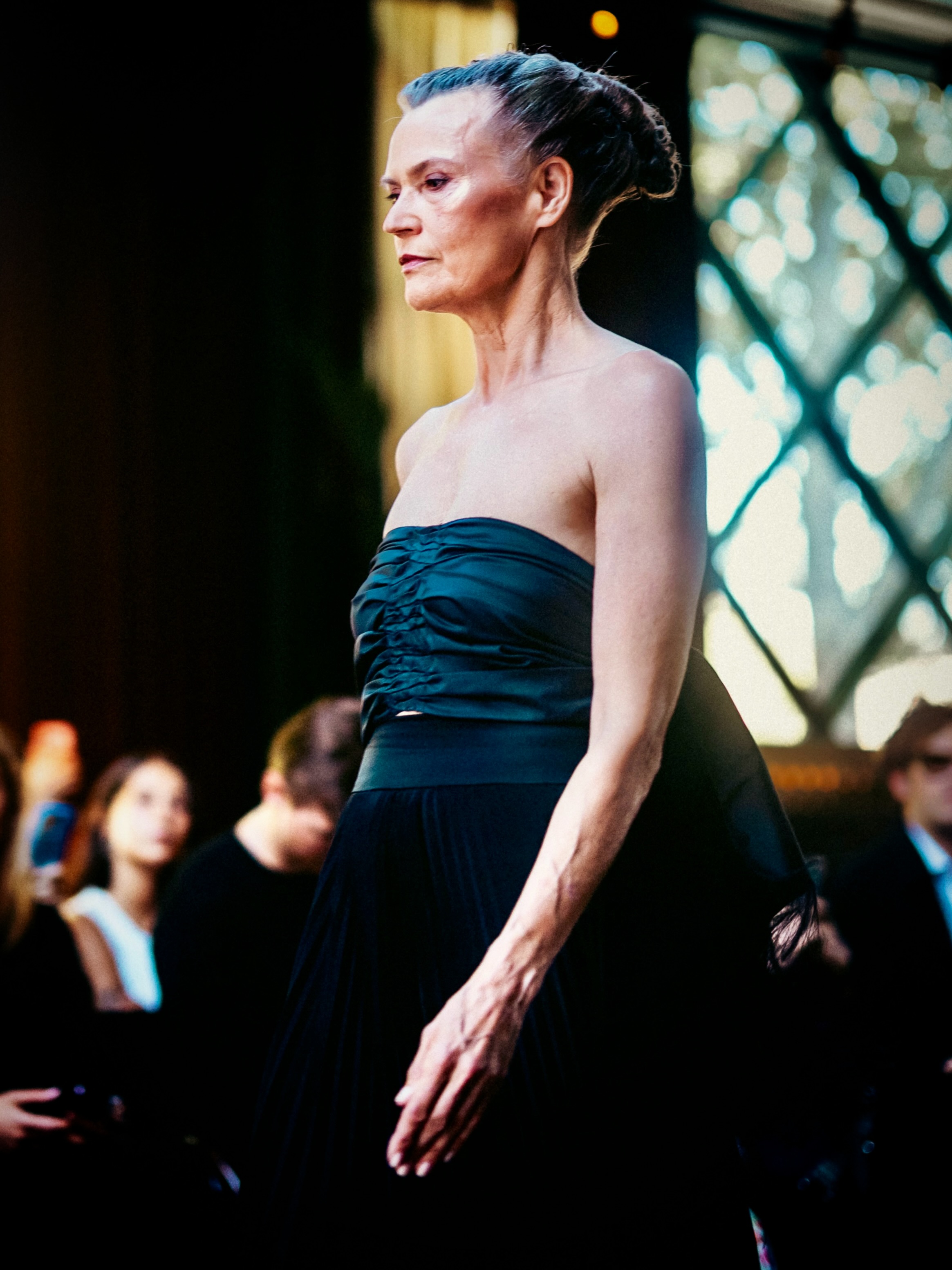 A model presents a dark blue look on the runway.