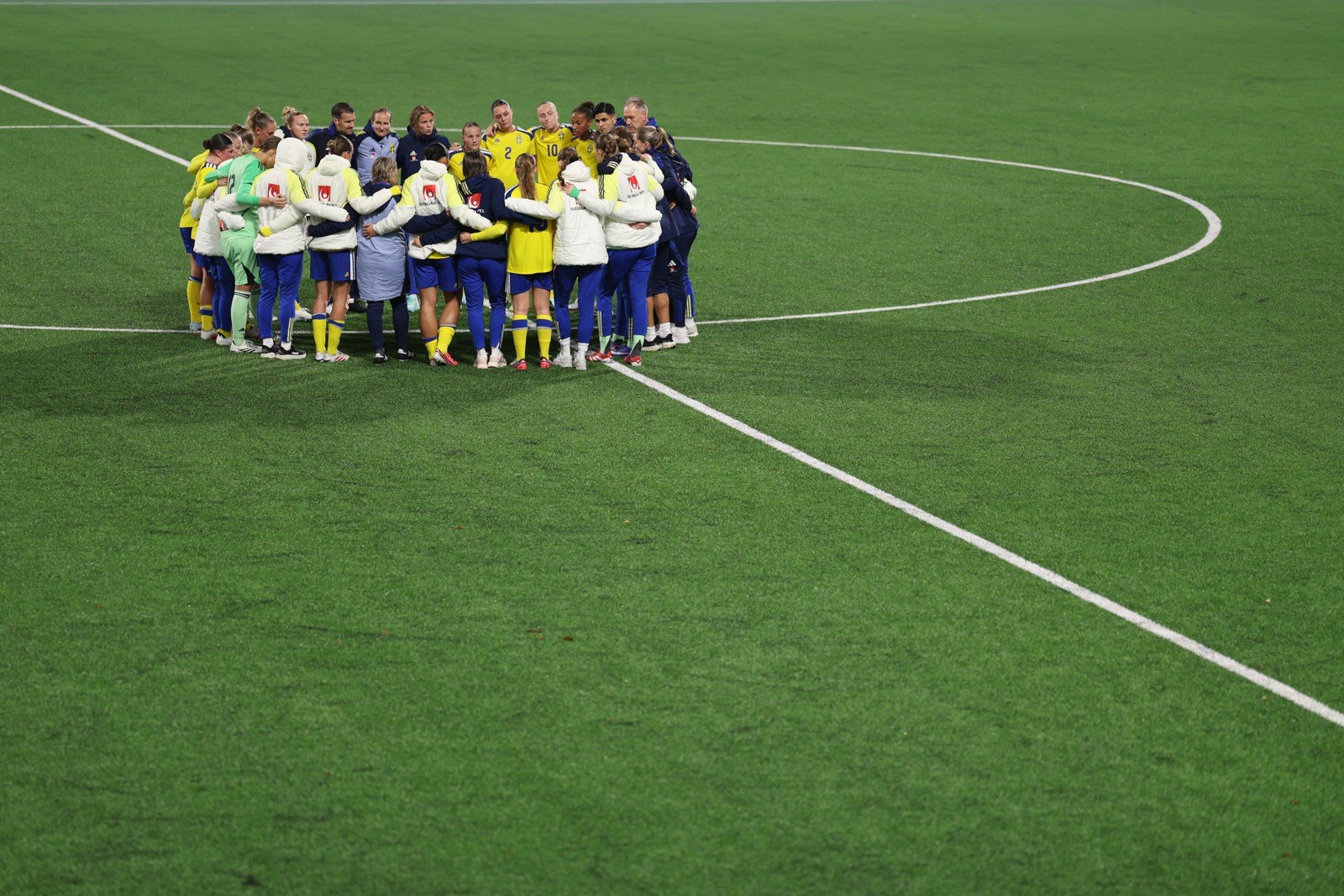 Sweden gathers in a team huddle on the pitch.
