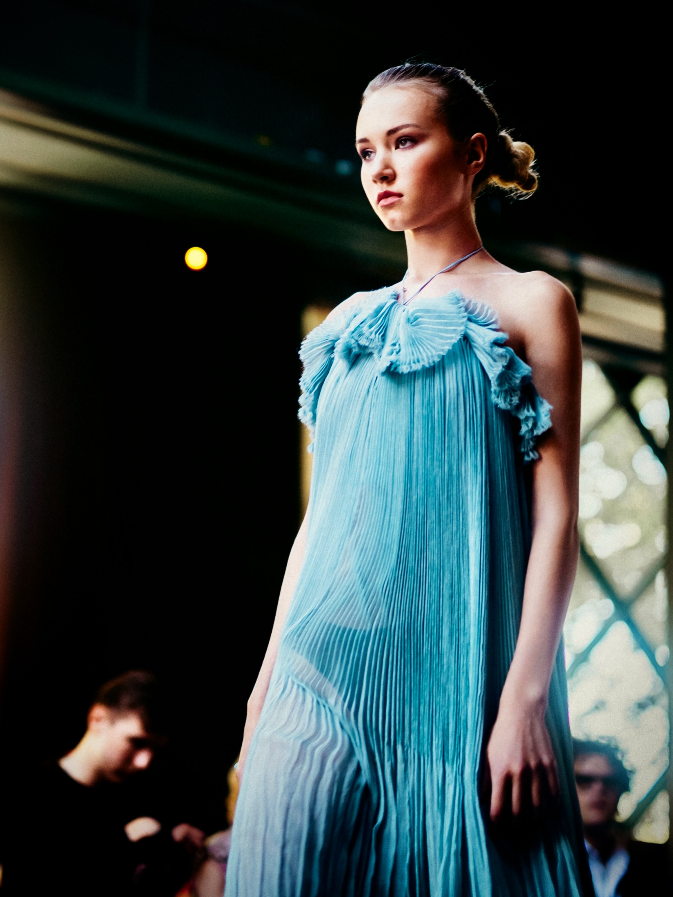 A model presents a turquoise look on the runway.