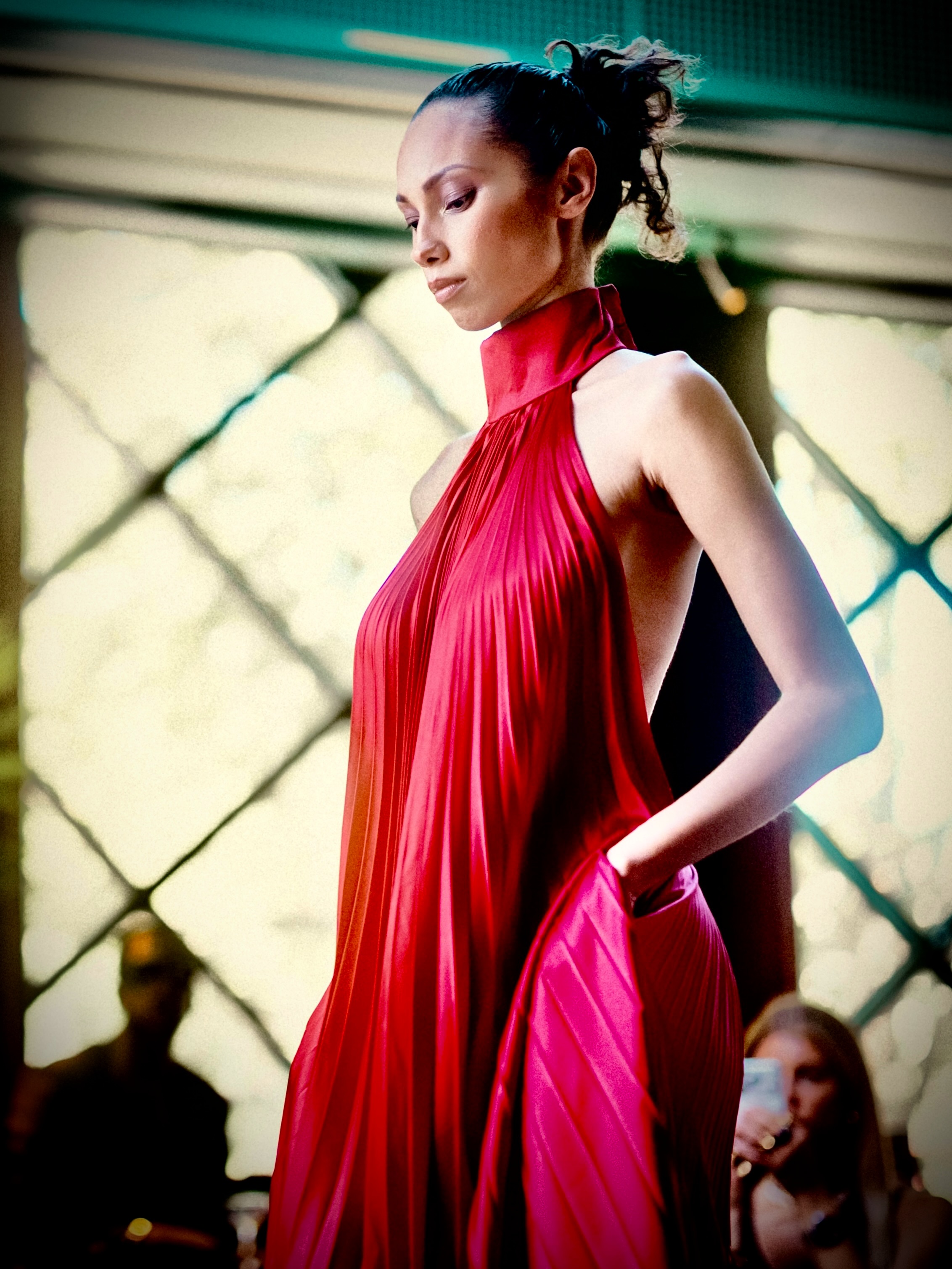 A model presents a red look on the runway.