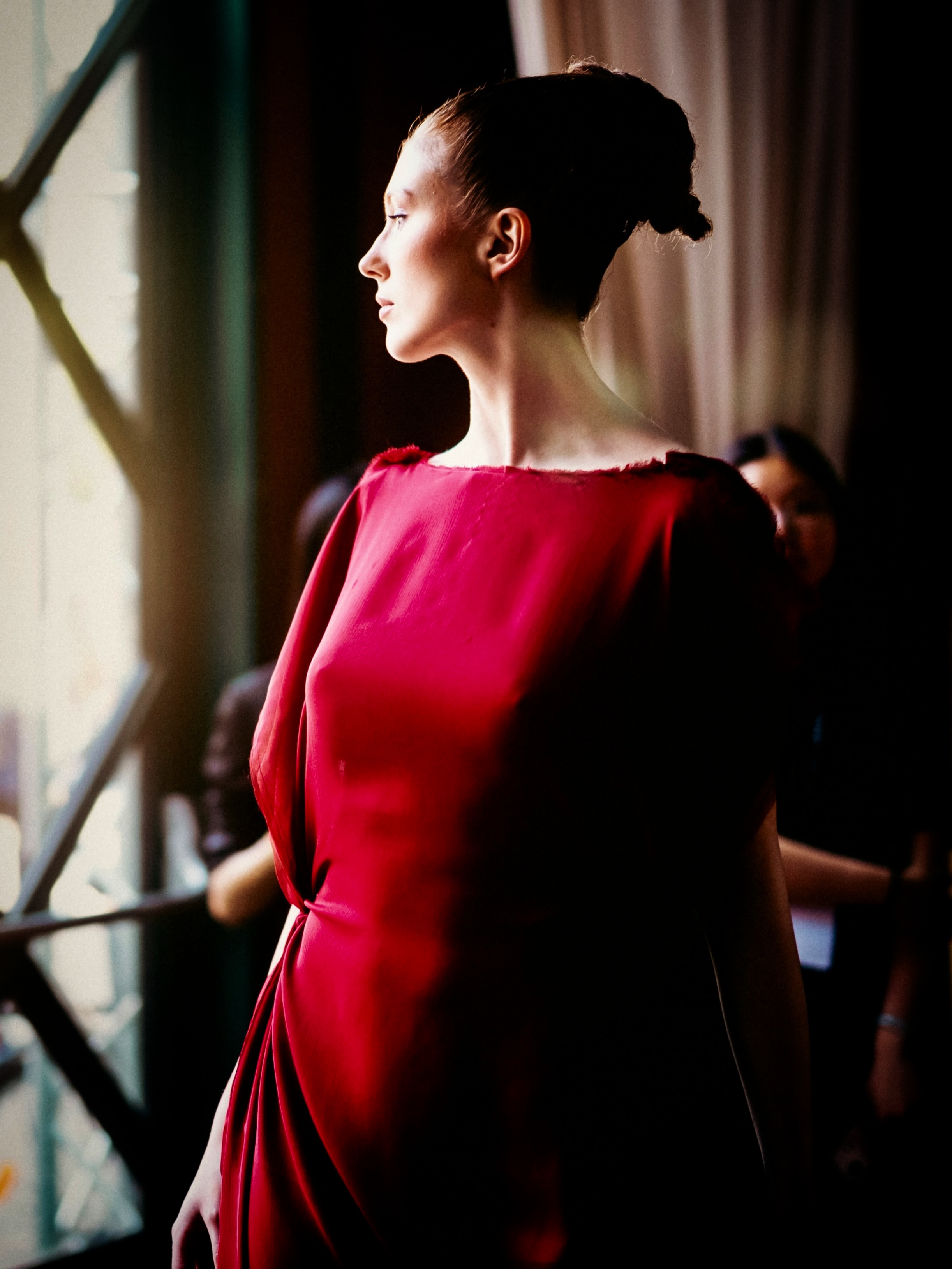 A model presents a red look on the runway.