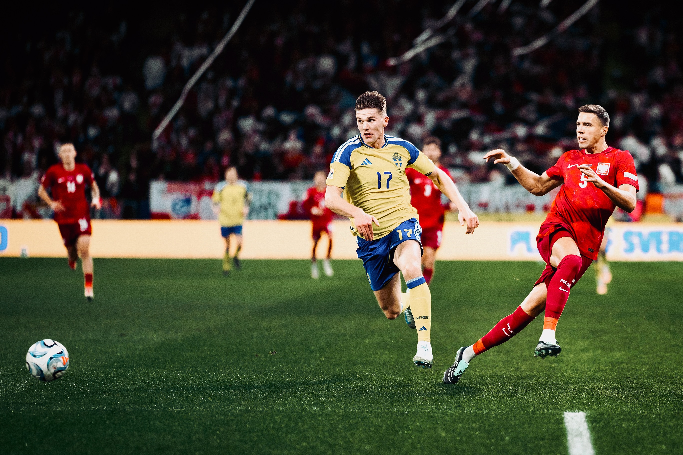 Swedish and Polish players chase the ball.