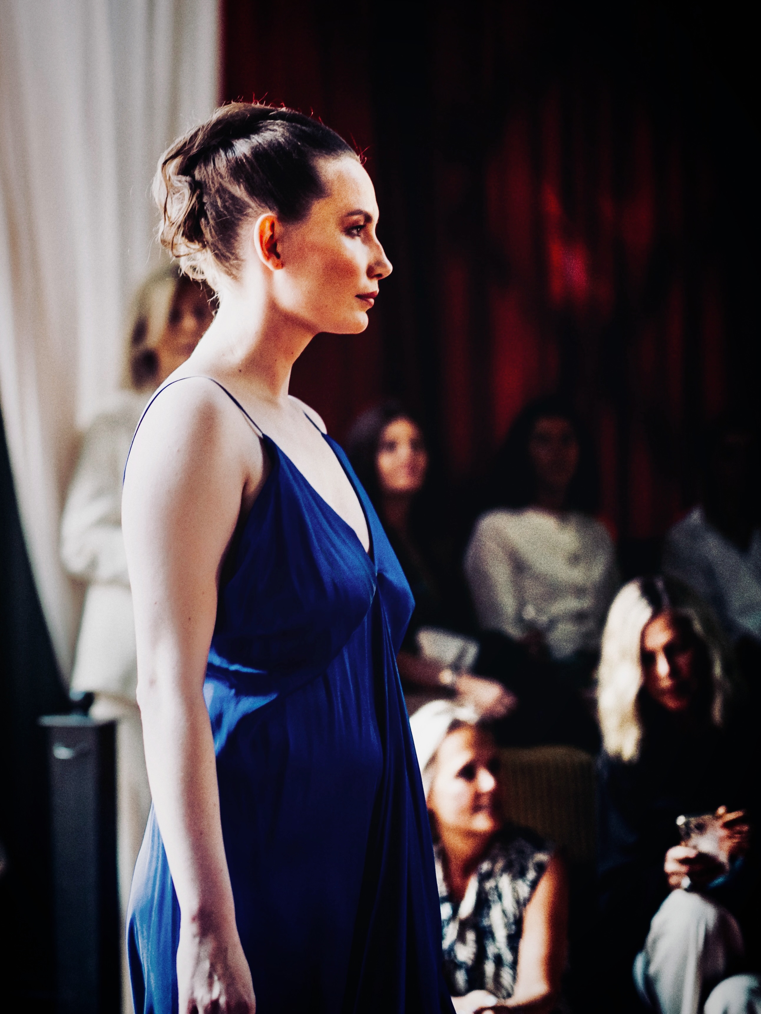 A model presents a blue look on the runway.