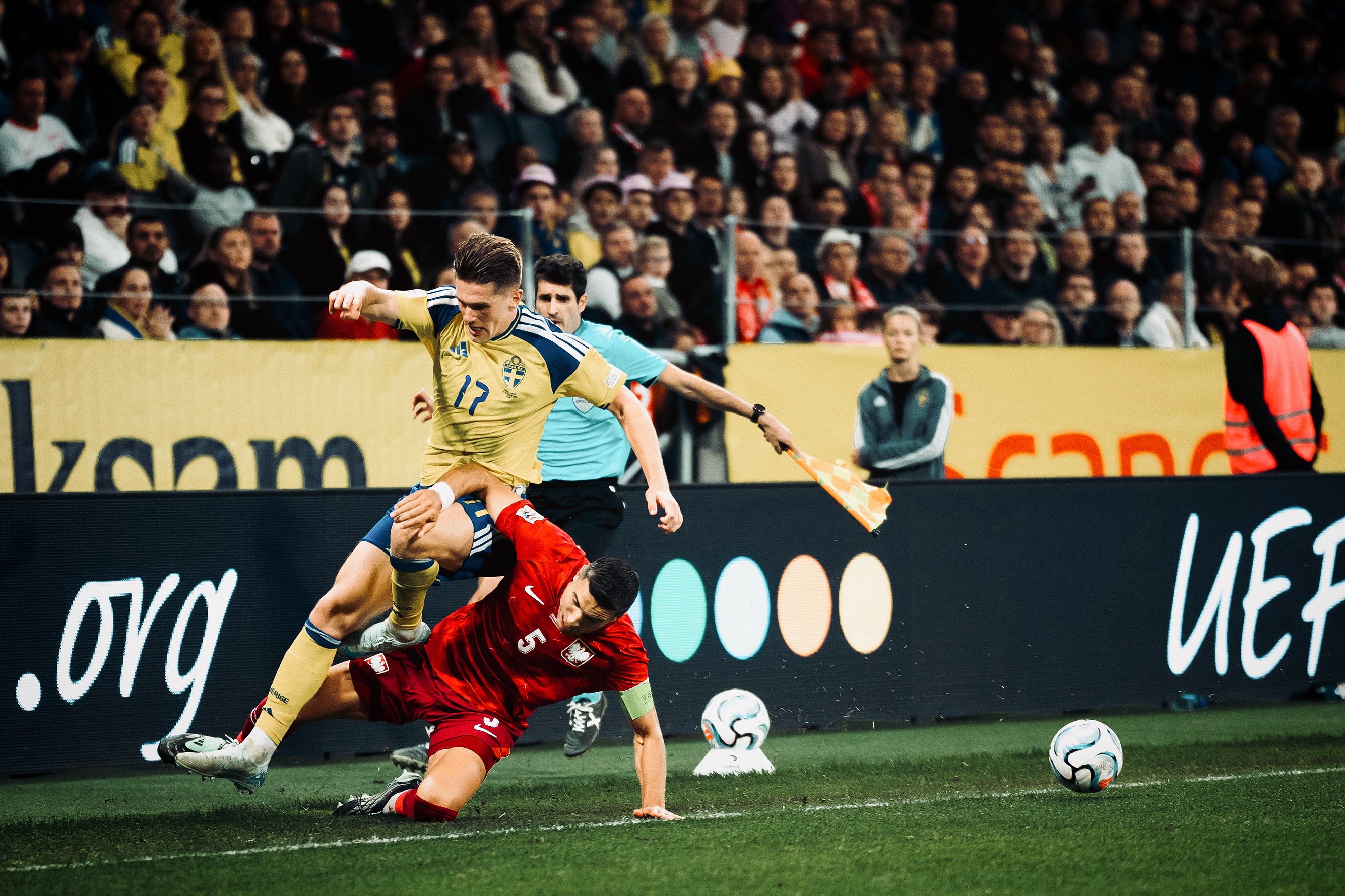 Players challenge for the ball near the touchline.