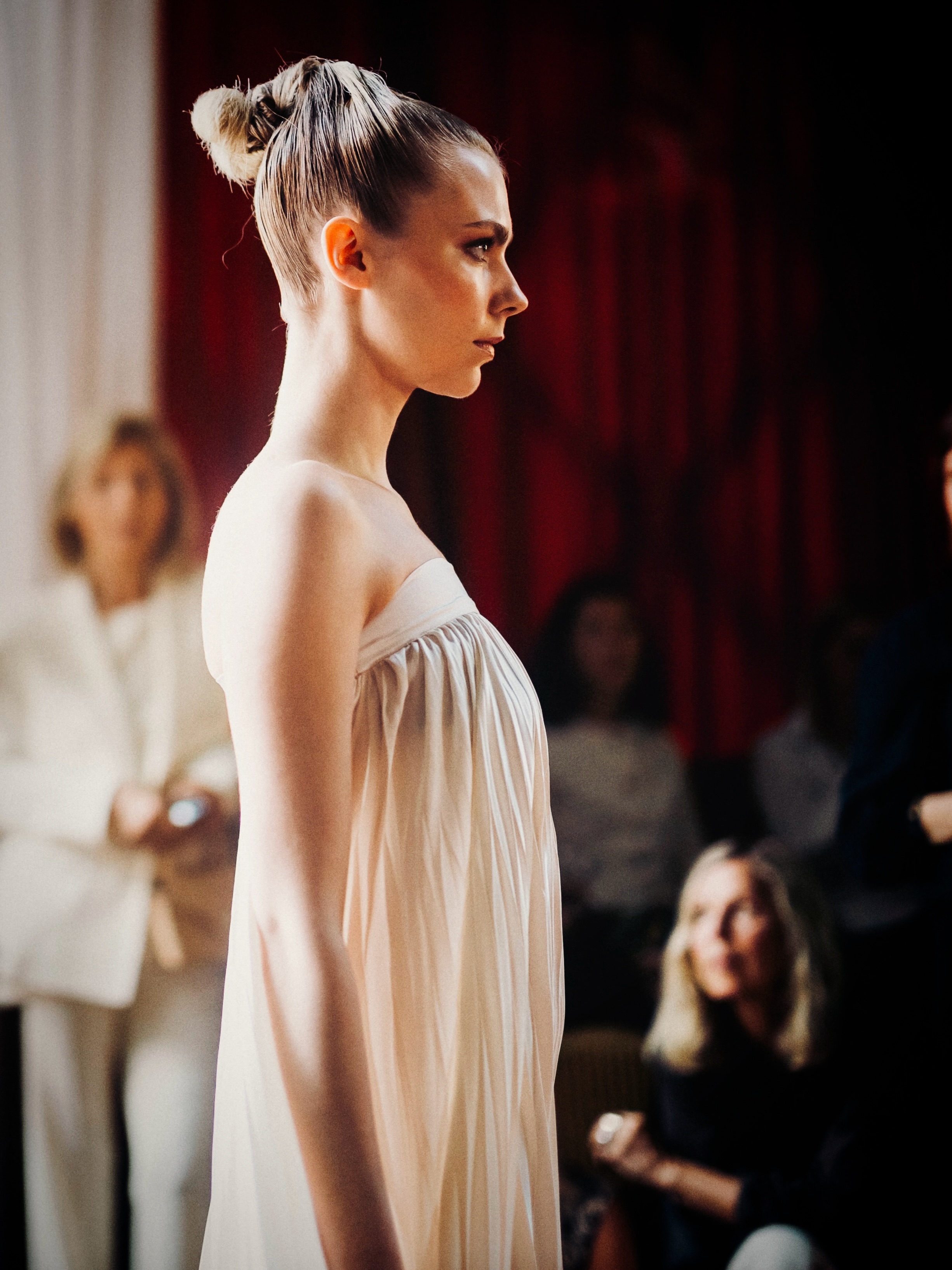 A model presents a white look on the runway.
