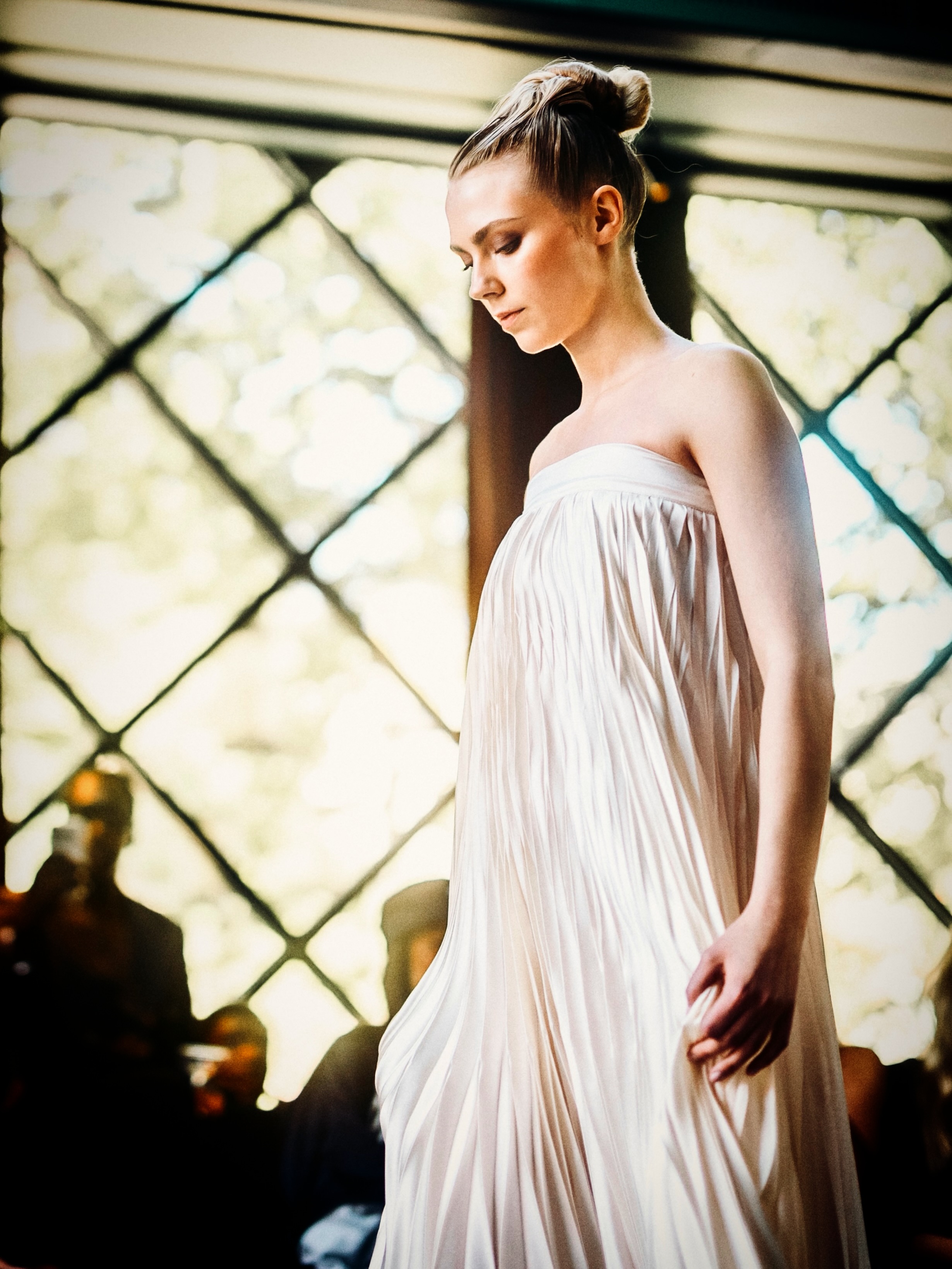A model presents a white look on the runway.