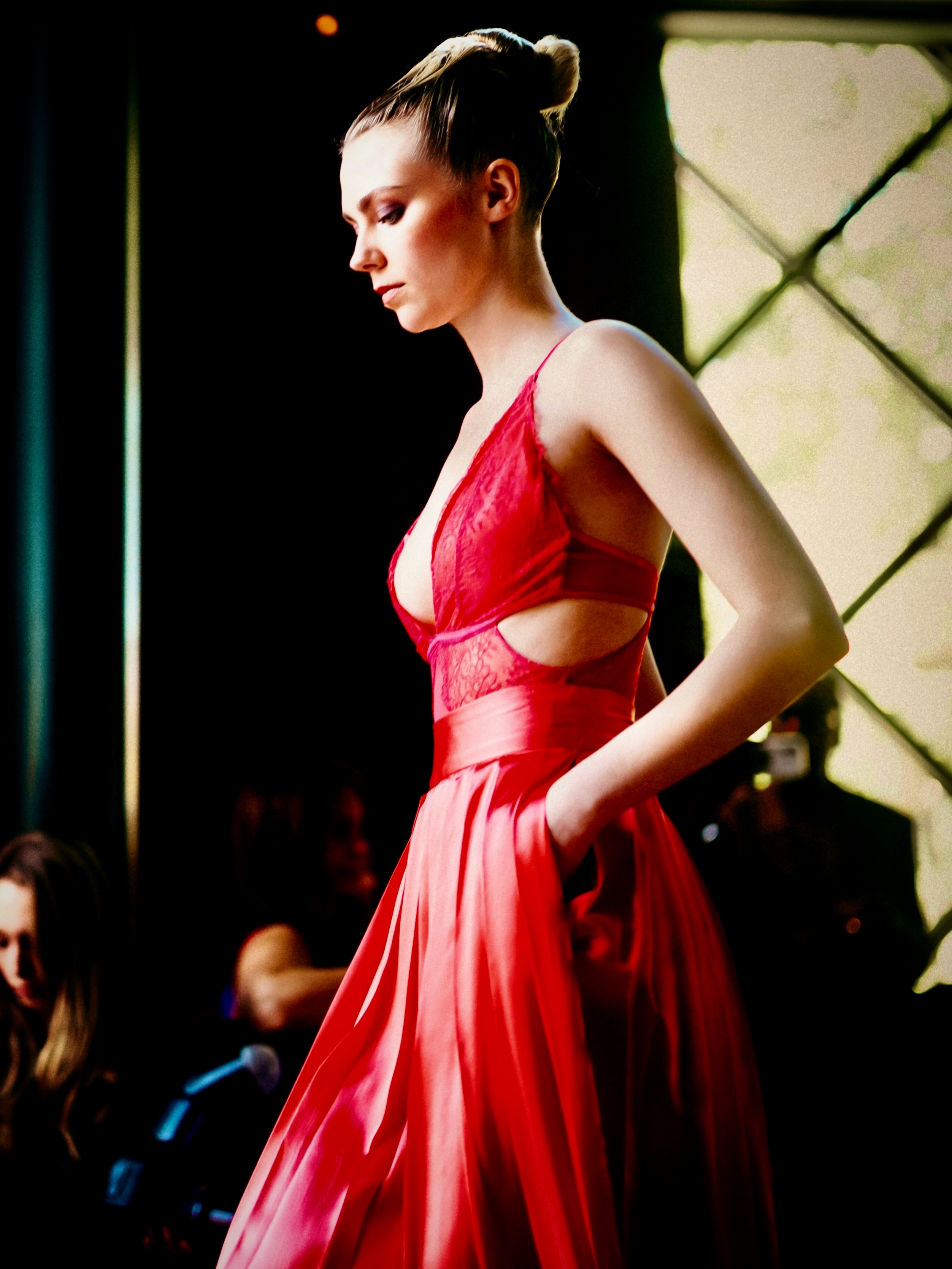 A model presents a red look on the runway.